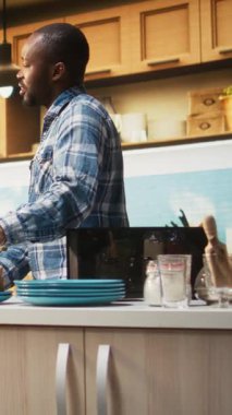 Dikey Afrikalı Amerikalı çift ekmeği ekmek kızartma makinesinden çıkarıyorlar ve kahvaltılarını evde sabahların güzelliğiyle sağlıklı bir yaşam tarzı için yapıyorlar. Birliktelik