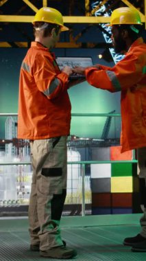 Dikey Görüntü Offshore mühendisleri, gece, petrol platformunda, petrol ve gaz emisyon takibi ve güvenli sondaj sondaj sondajı operasyonlarını güvence altına alarak telsiz aracılığıyla iletişim kuruyorlar. Kamera A.