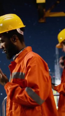 Dikey Video Afrikalı Amerikalı çevre subayı, denizdeki yaşam alanından petrol ve doğalgaz çıkarmayı yönetmek için kıyı platformunda radyo aygıtı, emisyon izleme cihazı ile iletişim kuruyor. Kamera B