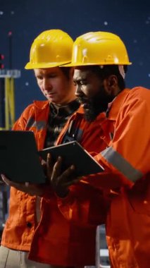 Dikey Görüntü Offshore çeşitli işçiler sondaj sondaj sistemlerini laptop ve tabletle izleyerek, endüstriyel platformdan doğalgaz ve petrol çıkarmayı yönetirler. Petrol ve gaz endüstrisi. Kamera B.