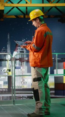 Vertical Video Offshore mühendisi denizaşırı platformda petrol üretimini izliyor, performans için emisyon takibini değerlendirmek için tablet kullanıyor. Kuzeyde petrol ve gaz sondaj operasyonlarının sağlanması