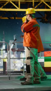 Dikey Video İşçisi, Aurora Borealis altındaki kıyı petrol platformunda radyo istasyonları aracılığıyla iletişim kurarak, emisyonları azaltmak ve deniz habitatlarının çıkarılmasını desteklemek için sondaj sondaj sondaj sondaj sistemlerini yönetir. Kamera.