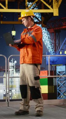 Sanayi platformunda verimli doğalgaz ve petrol çıkarmak için dizüstü bilgisayarla kıyı sondajı operasyonunu dikey video uzmanı değerlendirdi. Petrol endüstrisinin çevresel etkisi