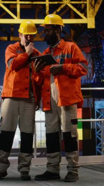 Dikey Görüntü Offshore petrol kulesi mühendisleri sondaj operasyonlarını gözlemlemek için telsiz kullanırlar, bu da kalın kasklar ve turuncu ceketlerle güvenliği sağlar. Verimli doğalgaz ve fosil yakıt çıkarma