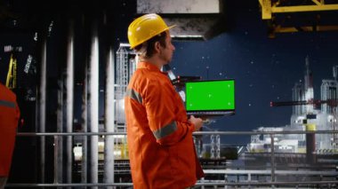 Sanayi mühendislerinin yanındaki krom anahtar kıyı sondajında petrol ve akaryakıt üretimini denetleyerek doğal gaz ve petrol üretimi için endüstriyel araçları izliyor. Petrol endüstrisi. Kamera A.