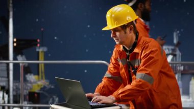 Deniz aşırı bir petrol platformunda terleyen ve gerilim altında çalışan çevre mühendisi, petrol ve doğalgazın verimli bir şekilde çıkarılmasını sağlamaya çalışıyor. Denizcilik operasyonları. Kamera B.