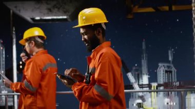 Offshore işçisi denizdeki sondaj sondajı operasyonlarını yönetmek için telsiz kullanıyor ve doğru ve verimli bir petrol çıkarma sağlıyor. Petrol ve gaz endüstrisinde yakıt üretimi. Kamera B.