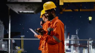 Offshore çevre memuru, petrol platformundan doğal gaz kaynakları alımını desteklemek amacıyla deniz ekosistemi fosil yakıt çıkarma üzerinde odaklanarak, tablet uygulamasında sondaj operasyonlarını denetlemektedir. Kamera B.