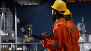 Offshore platform çalışanı dizüstü bilgisayar kullanarak risk değerlendirme raporlarını değerlendiriyor, petrol ve doğal gaz üretiminin verimli bir şekilde yönetilmesini sağlıyor. Fosil, üretim endüstrisini körüklüyor. Kamera B.