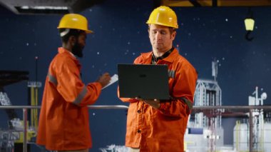 Deniz aşırı sondaj platformunda mühendis telsiz hakkında fikir alışverişinde bulunuyor. Yakıtı ve petrol sondajını koordine ediyor. Verimli fosil yakıt üretimi. Kamera B.