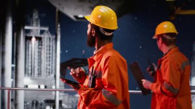 Endüstriyel mühendis, doğal gaz ve petrol çıkarırken tablet kullanarak kıyı sondaj sondaj sondaj sistemlerini inceler. Endüstri için verimli petrol üretimi sağlanıyor. Kamera B.