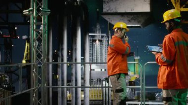 Çevre memuru kuzey ışıkları altında kıyı sondajında tablet kullanarak platformda petrol ve yakıt alımını sağlıyor. Petrol ve gaz üretim endüstrisine uyum. Kamera A.