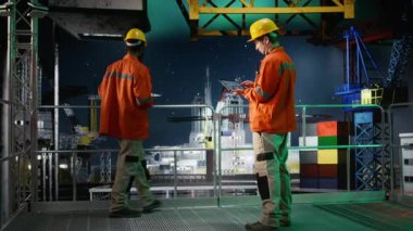 Offshore mühendisi denizaşırı platformda petrol üretimini izliyor, performans için emisyon takibini değerlendirmek için tablet kullanıyor. Kuzey ışıkları altında petrol ve gaz sondaj operasyonlarını sağlama almak. Kamera A.