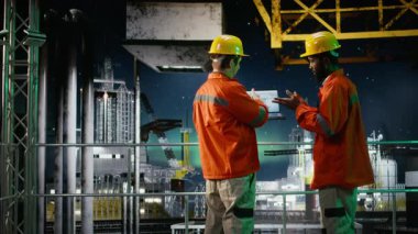 Çevre memurları aurora borealis altındaki kıyı petrol platformunu inceleyerek benzin çıkarma mühendisliğini izlemek için dizüstü bilgisayar kullanıyor. Okyanustan petrol üretim stratejisi. Kamera A.