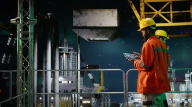 Offshore endüstriyel mühendisler petrol platformunda verimli petrol ve petrol çıkarma faaliyetlerini garanti altına almak için profesyonel denetim, emisyonları ve risk faktörlerini takip ediyorlar. Kamera A.