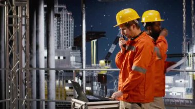 Offshore sondaj kulesi mühendisi meslektaşlarıyla telsiz aracılığıyla konuşuyor, verimlilik için petrol çıkarma sistemlerini izliyor. Platformdaki karbon ayak izini en aza indirmeye çalışıyorum. Kamera B.