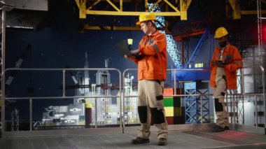 Endüstriyel platformda verimli doğal gaz ve petrol çıkarmak için dizüstü bilgisayarlı erkek profesyonel sondaj sondajı operasyonu. Petrol endüstrisinin çevresel etkisi. Kamera A.