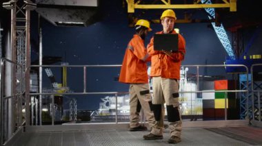 Deniz aşırı sondaj platformunda mühendis telsiz hakkında fikir alışverişinde bulunuyor. Yakıtı ve petrol sondajını koordine ediyor. Verimli fosil yakıt üretimi. Kamera A.