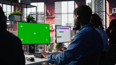 Arama merkezi ajanı yeşil ekran PC kullanarak müşterilere adım adım rehberlik ediyor. Mutlu müşteri merkezi çalışanı krom anahtar bilgisayar kullanıyor, müşteriler için teşhis sorunları, kamera B
