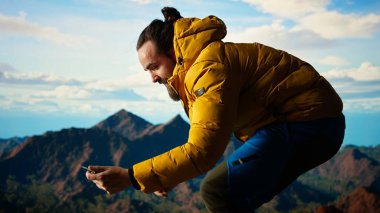 Düşüncesiz gezgin güvenlik önlemlerini göz ardı ediyor ve fotoğraf çekmeye çalışırken telefonunu düşürüyor. Yürüyüşçü, dikkatsiz ve dikkatsiz bir şekilde kendini tehlikeye atarken buldu. Kamera A.