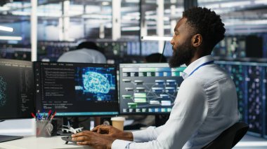 Sunucu merkezi mühendislik ekibi yapay zeka veri analizi grafiklerini yorumluyor. Öngörü sistemi ölçümleri gösteren yapay zeka programı kullanan ekip çalışması veri merkezi meslektaşları, kamera B