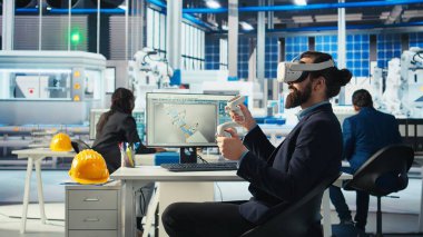 Robot kolların montaj hatlarına güneş panelleri yerleştirme performansını izlemek için VR kulaklık kullanan fotovoltaik fabrika işçisi. Sanal gerçeklik teknolojisi kullanarak güneş santrali makinelerini denetleme uzmanı