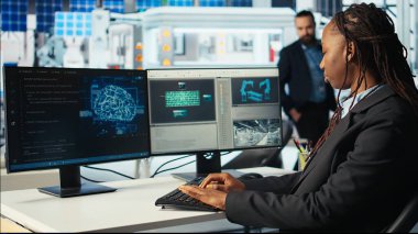 Fotovoltaik fabrikasında yazılım geliştirici robot kollarının montaj hatlarına güneş panelleri yerleştirmesini denetlemek için yapay zeka kullanıyor. Sistem yöneticisi güneş santralini AI, kamera A kullanarak yükseltiyor