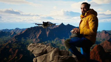 Dağ gezgini profesyonel bir video çekiyor ve manzaralı zirvelerde geziniyor, yolculuğunu küresel bir izleyiciyle paylaşıyor. Modern doğa yürüyüşçüsü İHA 'sının video blogunu kaydediyor. Kamera A.