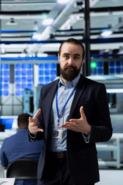 Solar Tech danışmanı güneş enerjisi üretimiyle ilgili bir tartışmayı güvence altına alıyor, çalışanlara yenilenebilir enerji verimliliğini güvence altına almaları için brifing veriyor. Bir imalat fabrikasında iş danışmanı.