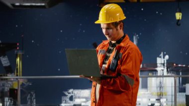 Deniz aşırı platformda gülümseyen mühendisin portresi dizüstü bilgisayarda analiz yapıyor, sondaj işlemleri verimli petrol ve yakıt çıkarma ile aynı hizada. Doğal gazlı deniz ekosistemi. Kamera B.