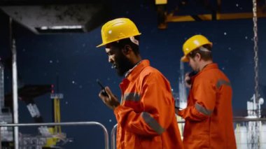 Afrika kökenli Amerikalı çevre subayı, denizdeki yaşam alanından petrol ve doğalgaz alımını yönetmek için kıyı platformunda radyo aygıtı, emisyon izleme cihazı ile iletişim kuruyor. Kamera B.