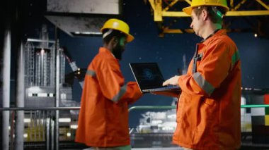 Mühendis, deniz aşırı petrol platformu operasyonları için yapay zeka sistemlerini inceliyor, nöral ağlar aracılığıyla yakıt alımını ve derin öğrenme simülasyonunu yönetiyor. Yakıt üretimi. Kamera A.