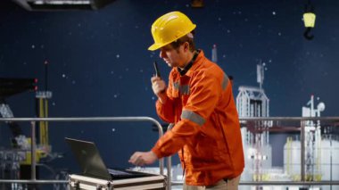 Sondaj kulesindeki erkek işçi telsizle denizaşırı platformlarda iletişim kurarak petrol ve gaz çıkarma sektöründeki meslektaşlarını koordine ediyor. Deniz kirliliği. Kamera B.