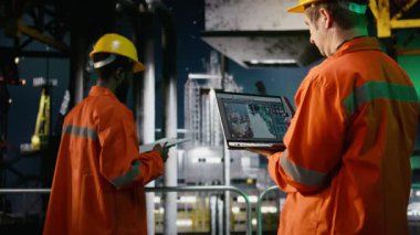 Açık deniz sondaj kulesinde erkek mühendis aurora borealis altında emisyon sistemlerini denetliyor, deniz ortamlarında uyum ve sorumlu petrol çıkarma garantisi veriyor. Kamera A.