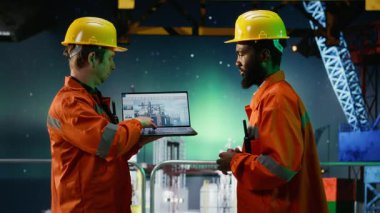 Offshore mühendisleri, geceleyin, petrol platformunda, Aurora Borealis 'in altında, petrol ve gaz emisyonu takibi ve güvenli sondaj sondaj sondajı operasyonlarını güvence altına alarak telsiz aracılığıyla iletişim kuruyorlar. Kamera B.