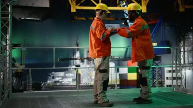 Offshore mühendisleri, geceleyin, petrol platformunda, Aurora Borealis 'in altında, petrol ve gaz emisyonu takibi ve güvenli sondaj sondaj sondajı operasyonlarını güvence altına alarak telsiz aracılığıyla iletişim kuruyorlar. Kamera A.