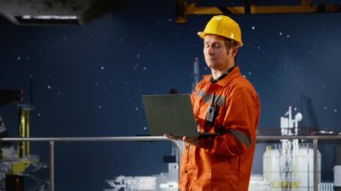 Sert şapkalı işçiler, sanayi platformundan kıyı sondaj platformunda sistem teftişleri yapıyor, deniz fosili yakıt çıkarma ve petrol üretim uygulamalarını izlemeye odaklanıyor. Kamera B.