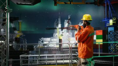Deniz petrol platformundaki siyah mühendis, denetimi koordine etmek için telsiz kullanıyor ve petrol üretimi sanayii için verimli doğalgaz ve akaryakıt üretimini sağlıyor. Offshore platformu. Kamera A.