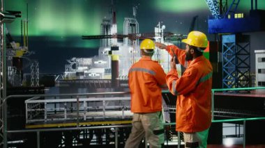 Aurora Borealis 'in altındaki denizaşırı işçiler telsizle konuşuyor ve sondaj sistemlerini izliyorlar, geceleri fosil yakıt çıkarma operasyonlarına odaklanıyorlar. Okyanus ekosistemi. Kamera A.