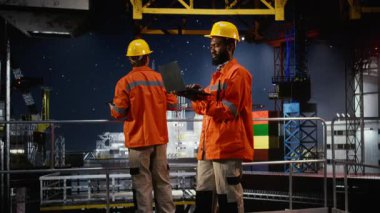 Offshore platform çalışanı dizüstü bilgisayar kullanarak risk değerlendirme raporlarını değerlendiriyor, petrol ve doğal gaz üretiminin verimli bir şekilde yönetilmesini sağlıyor. Fosil, üretim endüstrisini körüklüyor. Kamera A.