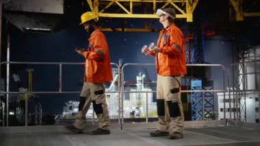 Erkek mühendis, kıyı sondaj kulesini incelemek için sanal gerçeklik ekipmanı kullanıyor, petrol platformu işlemleri, bakım ve imalat sistemleri için gelişmiş görselleştirme uyguluyor. Kamera A.