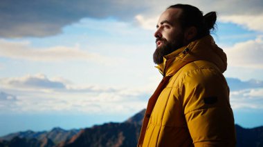 Gezgin, yüksek rakımlı yabanda tek başına duruyor nefes kesen manzaraya hayran, temiz havanın ve çarpıcı dağ manzarasının tadını çıkarıyor. Huzurlu atmosfer farkındalığa ilham verir. Kamera A.