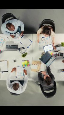 Şirket etkinliği sırasında bütçe ve kaynak tahsisi konusunda danışmanlık yapan iş adamlarının dikey videosu. Çok uluslu şirket çalışma ekibi stratejik planlama için verileri analiz eder. Kamera A.