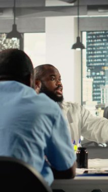 Vertical Video Professional çalışanları ofiste rapor paylaşımı üzerinde birlikte çalışıyorlar. Proje planlaması, analitik ve kurumsal kalkınma ölçümlerinde çeşitli çalışma ekipleri işbirliği yapmaktadır. Kamera B.