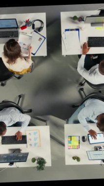 Dik Video Üst Ofisteki personelin aşağı görüntüsü iş stratejisi ve piyasa araştırmasını tartışıyor. Çeşitli iş arkadaşları hedefleri, hedefleri ve performans ölçümlerini düzenlemek için belge ve diyagramları değerlendirir