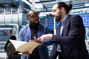 Güneş enerjisi üretimini ele almak için fabrikada toplanan iş arkadaşları fotovoltaik üretim sürecinde takım çalışması gösteriyor. Fabrikada yeşil yenilenebilir enerji sistemi yönetimi.