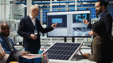 Fotovoltaik fabrikasındaki yönetim yöneticileri ve yatırımcılar güneş enerjisi üretim kapasitelerini genişletme amaçlı yatırım stratejilerini belirlemek için pazar eğilimlerini analiz ediyorlar, kamera A