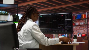 Hüsrana uğramış borsa simsarı üzgün, düşen hisse senedi fiyatlarını, kırmızı çizelgeleri ve kayıpları gösteren bilgisayar ekranlarına bakıyor. Yatırımcı, hisse senedi hisselerindeki düşüşe bakarken baskı altında. Kamera A