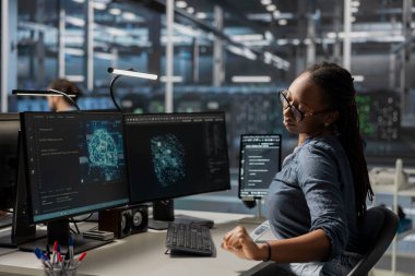 Veri merkezindeki teknisyen yapay zeka teknolojisini kullanarak simülasyonları çalıştırıyor. Verilerden bilgi toplamak ve otomatik donanımları otomatik hale getirmek için bilişsel hesaplama algoritmaları kodlayan Afrikalı Amerikalı bilişim uzmanı