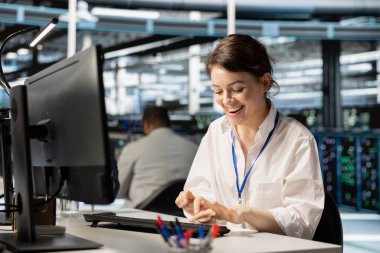 Veri merkezindeki radyasyon programcısı istikrarlı performans göstergeleri gösteren altyapı sağlık raporuyla uyarılıyor. Sunucu çiftliğindeki aşırı neşeli kadın operasyonları başarıyla tamamladıktan sonra çok mutlu oldu